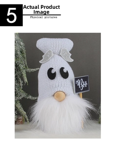 Detail of white knitted Halloween gnome with wings and a Boo sign on snowy background