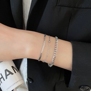 Close-up of three-piece silver bracelet set with snake, bead, and Cuban link chains