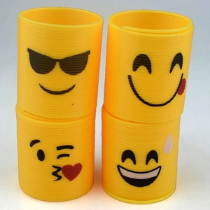 Detailed view of four mini yellow spring toys with classic emoji face patterns