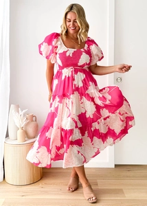 Close-up of pink floral dress featuring elastic pleated bodice and tiered skirt detail