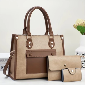 Detailed view of beige faux leather tote set with pebble texture and brown straps