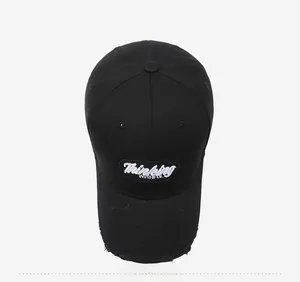 Close-up of black cotton baseball cap with white embroidery and distressed brim details