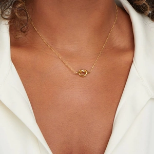 French vintage 14K gold plated knot pendant necklace worn on a classic white shirt