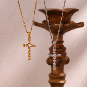 Detail showing gold and silver cross necklaces with central zircon and beaded chain