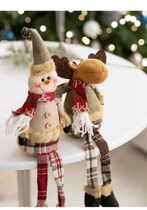 Detail of Christmas snowman and elk plush dolls with knitted long legs on a white table