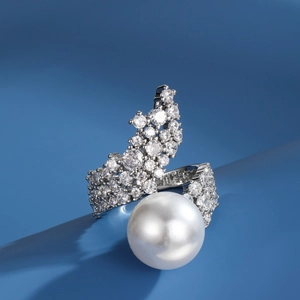 French style pearl ring with zircon accents on a silver band over blue background