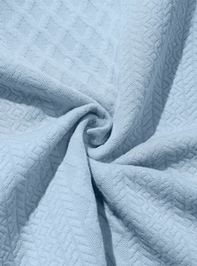 Detailed view of light blue knitted fabric with premium geometric diamond weaving texture