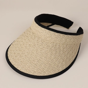 Detail of straw woven visor hat with beige texture and black ribbon edge design