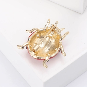 Detailed back view of a golden alloy ladybug brooch showing the secure pin fastener