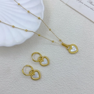 Detail of 18K gold-plated heart necklace and earrings with white shell inlay on background
