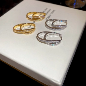 Macro shot of 18k gold and silver U-shaped hoop earrings with shimmering cubic zirconia