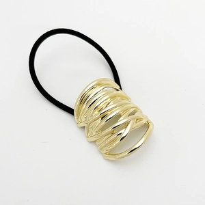 Detailed view of elastic hair tie with layered gold spiral metal buckle on white background