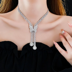 Detail shot of multi-layer silver necklace featuring a rhinestone butterfly pendant on a model