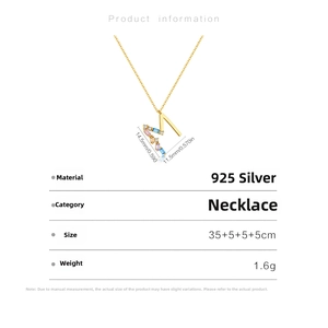 Macro view of gold 925 sterling silver M letter pendant with multicolor crystals