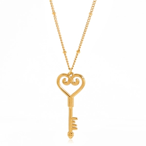 Détail du collier avec pendentif clé en forme de cœur plaqué or 18 carats sur fond blanc