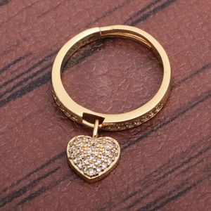 Elegant gold plated heart charm ring featuring white zircon on a textured leather surface