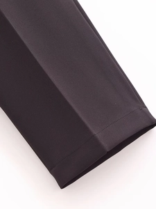 Detailed close-up of high-quality stitching on the black wide-leg suit pants hemline