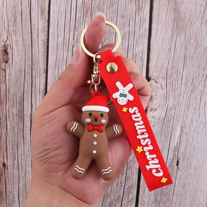 Close-up of a brown PVC gingerbread man keychain with a red strap and metal clip