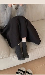 Détail de chaussettes en coton à rayures avec motifs noir et gris et bord côte
