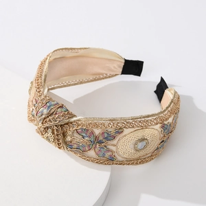 Close-up of lace embroidery headband with sequins and beads on a white stand