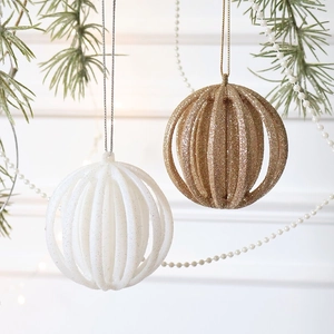 Sparkling champagne and white hollow lantern ornaments hanging on green pine branches