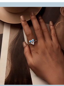 Detail of s925 silver iris ring with blue enamel petals and sparkling zircon stones