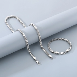Polished silver stainless steel Franco chain necklace and bracelet set on display