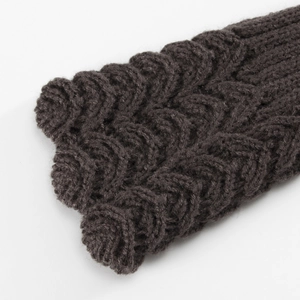 Macro shot of dark grey knit arm warmers featuring a thick textured wave pattern