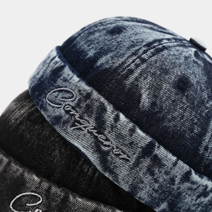 Detailed macro of washed denim docker hats featuring premium embroidery and texture