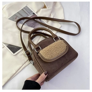 Detail of plush beige faux fur trim and brown suede texture on a crossbody handbag