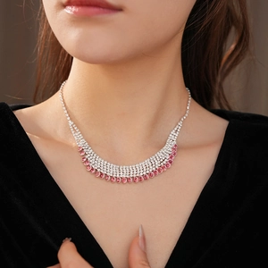 Close-up of tiered silver fringe necklace with clear and pink rhinestones on a model