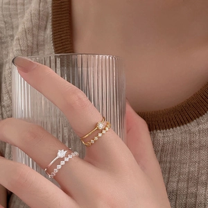 925 silver layered ring set with zircon stones on a model holding a glass cup