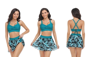 Tre viste del costume da bagno a due pezzi con top blu e gonna con stampa tropicale
