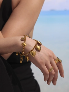 Detailansicht von 18K Gold Herz und Elefant Armband geschichtet mit Goldringen