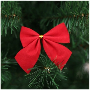Red Christmas bow ornament hanging on green pine branch for festive tree decoration