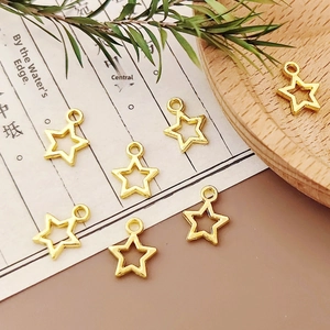 Detailed view of golden alloy star pendants for DIY jewelry making on vintage paper
