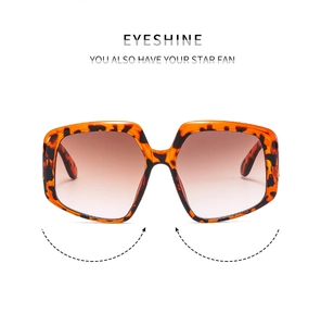 Detail view of large irregular sunglasses with tortoiseshell frame and brown gradient lenses