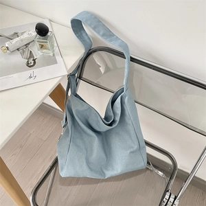 Macro detail of sky blue canvas tote bag showing wide strap and spacious interior design