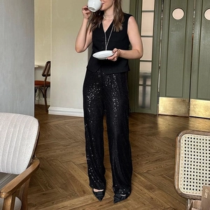 Detail of high-waisted black sequin wide-leg pants for party wear with shimmering texture