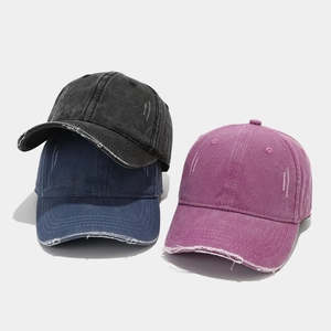 Detail of distressed baseball caps in black, navy and purple with frayed brim texture