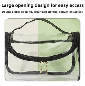 Detail view of the large semicircular opening and golden double zipper on the clear makeup bag