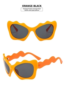Detail of orange wave sunglasses with black lenses featuring Y2K cat-eye design