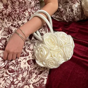 Detail of white handmade fabric rose floral round handbag with smooth silk handles