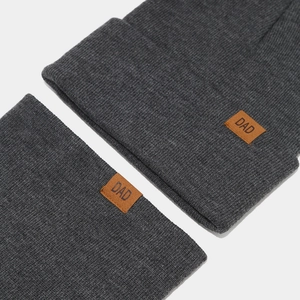 Detail of dark gray knit hat and scarf set featuring a brown leather DAD patch