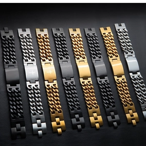 Detail of assorted Cuban chain bracelets in black, gold, and silver finishes with nameplates