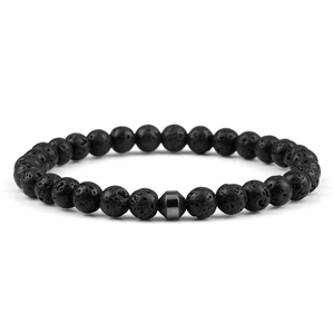 Macro shot of natural black volcanic lava stone beads and hexagonal hematite charm