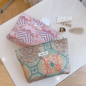 Traditional jacquard makeup bags with Chinese wave and floral patterns on white table