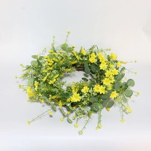 Detail of faux yellow daisy floral wreath on natural rattan vine base for wedding decor