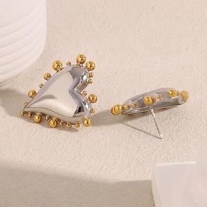 Macro shot of two-tone stainless steel heart earrings with gold beaded edges
