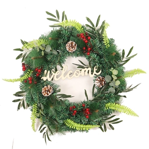 Christmas wreath with olive branches, pine needles, berries and wooden welcome sign